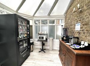 a kitchen with a black refrigerator in a room at Sleeplicity London Heathrow in Feltham