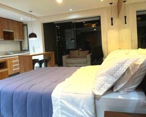 1 dormitorio con 1 cama grande y cocina en VILA OLIMPIA Studio próx à Faria Lima, en São Paulo