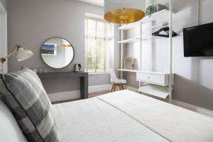 a bedroom with a bed and a mirror and a tv at Housel Bay Hotel in Lizard