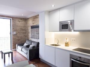 a kitchen and a living room with a couch at Enjoybcn Gaudi Apartments in Barcelona