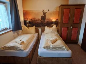 two beds in a room with a deer painting on the wall at Chalet Auhof Flachau in Flachau