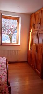 a bedroom with a bed and a window with a tree at Appartamento a Madonna di Campiglio in Madonna di Campiglio