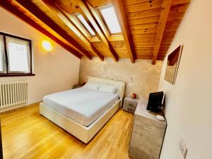 una camera con letto e soffitto in legno di Sonhozinho House Colico a Colico