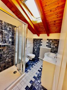 ein Bad mit einer Dusche, einem Waschbecken und einem WC in der Unterkunft Sonhozinho House Colico in Colico