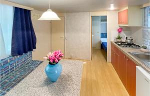 a blue vase with flowers on a counter in a kitchen at Pet Friendly Stacaravan in Tuoro sul Trasimeno