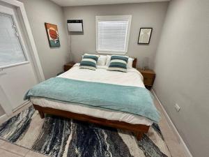 ein Schlafzimmer mit einem großen Bett mit blauen Kissen in der Unterkunft The Mini Coconut in Marathon