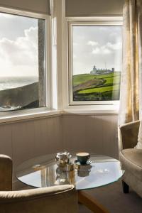 a coffee table in a room with two windows at Housel Bay Hotel in Lizard