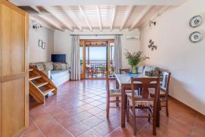a living room with a table and chairs and a couch at Althea Accommodation in Agnontas