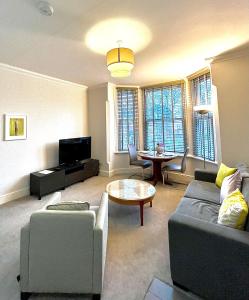 ein Wohnzimmer mit einem Sofa und einem Tisch in der Unterkunft Mode Apartments St Annes in Lytham St Annes
