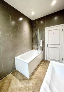 a bathroom with a white tub and a sink at Mode Apartments St Annes in Lytham St Annes