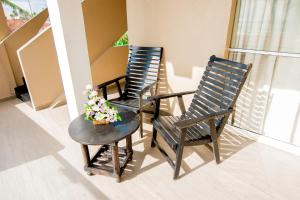 two chairs and a table with flowers on a balcony at Nico Beach Hotel in Hikkaduwa