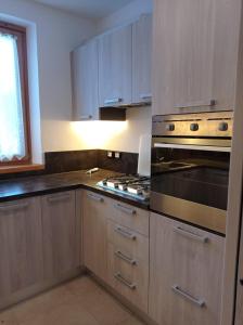 a kitchen with wooden cabinets and a stove top oven at Appartamento a Madonna di Campiglio in Madonna di Campiglio