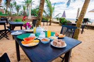 una mesa azul con comida en la playa en Nico Beach Hotel, en Hikkaduwa