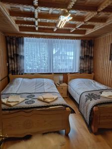 a bedroom with two beds and a window at Pokoje gościnne u Joanny in Groń