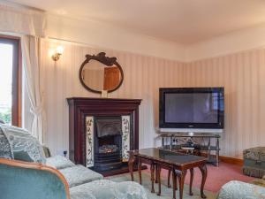 a living room with a fireplace and a tv at Glossoms Lodge in Scalford
