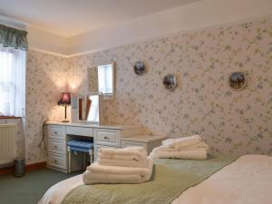 a bedroom with a bed with a desk and towels at Glossoms Lodge in Scalford