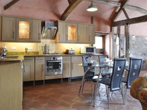 a kitchen with a table and chairs in a room at The Cart Shed in Kings Pyon