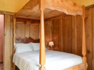 a bedroom with a bed with a wooden wall at The Cart Shed in Kings Pyon