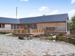 a house with a bench in front of it at The Cart Shed in Kings Pyon