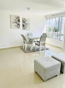 una sala de estar blanca con mesa y sillas en Apartamentos Amoblados Cali, en Cali