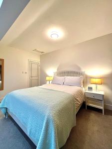 a bedroom with a large bed with two lamps at Mode Apartments St Annes in Lytham St Annes