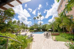 a courtyard with a swimming pool and palm trees at Hodelpa Garden Court in Santiago de los Caballeros