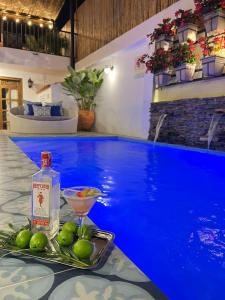 a table with a drink and a bowl of fruit next to a swimming pool at Matisia Hotel Boutique in Guaduas