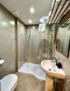ein Badezimmer mit einer Badewanne, einem Waschbecken und einem WC in der Unterkunft Mode Apartments St Annes in Lytham St Annes