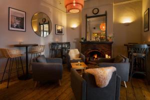 a bar with chairs and a fireplace in a room at Housel Bay Hotel in Lizard