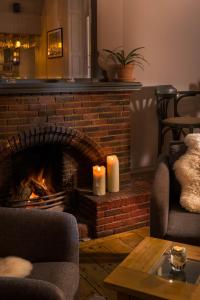 a fireplace with two candles in a living room at Housel Bay Hotel in Lizard