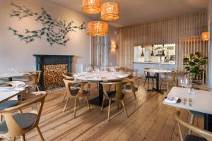 a restaurant with tables and chairs and a fireplace at Housel Bay Hotel in Lizard