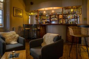 a bar with two couches and a bar with drinks at Housel Bay Hotel in Lizard +37 photos