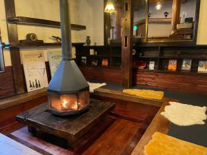 a fireplace in a room with wood floors and mirrors at Heidi Guest House in Yuzawa
