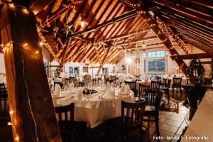 ein Esszimmer mit Tischen und Stühlen in einem Gebäude in der Unterkunft Hotel Gutshof Herborn in Herborn