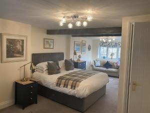 a bedroom with a large bed and a couch at The Cosy Nook Cottage Company - Cosy Cottage in Warcop