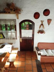 ein Wohnzimmer mit einer Holztür und einer Couch in der Unterkunft Cabaña del bosque 5 personas equipada totalmente in La Paloma