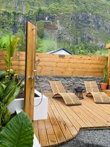 eine Holzterrasse mit zwei Stühlen und einem Zaun in der Unterkunft Villa Couleur Nature in Salazie