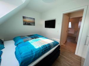 a bedroom with a bed with a blue comforter at Haus Leni in Butjadingen