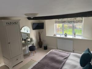 een slaapkamer met een bed en een raam bij The Cosy Nook Cottage Company - Cosy Cottage in Warcop