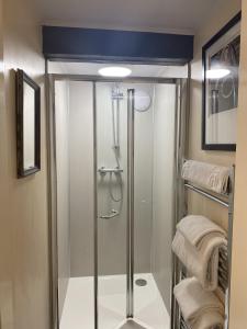 a shower with a glass door in a bathroom at The Cosy Nook Cottage Company - Cosy Cottage in Warcop