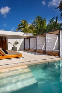 a villa with a swimming pool and a house at Illa Cozumel in Cozumel