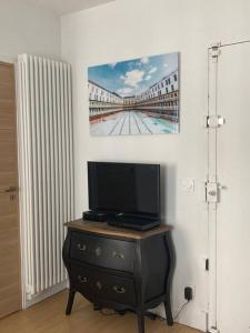telewizor na komodzie ze zdjęciem na ścianie w obiekcie Studio Saint Germain des près w Paryżu