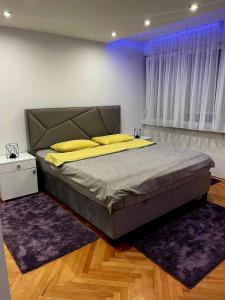 a bedroom with a large bed with yellow pillows at Nene in Banja Luka