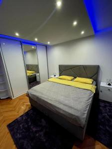 a bedroom with a bed with yellow pillows on it at Nene in Banja Luka