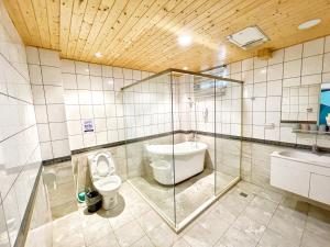 金寧鄉的住宿－微風海戀度假民宿，一间带卫生间和玻璃淋浴间的浴室
