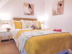 a bedroom with a large bed with a yellow blanket at Charming Cottage near Cartmel with free Spa access in Holker