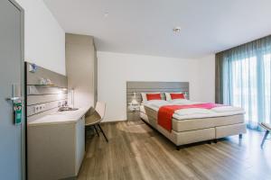 Schlafzimmer mit einem Bett, einem Schreibtisch und einem Waschbecken in der Unterkunft Schlosshotel Monrepos in Ludwigsburg