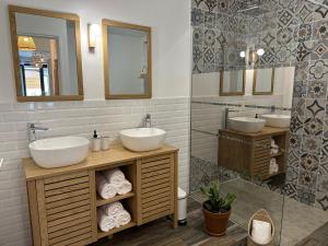 a bathroom with two sinks and a mirror at Villa Couleur Nature in Salazie