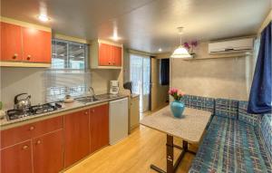 a kitchen with a table with a vase of flowers on it at Pet Friendly Stacaravan in Tuoro sul Trasimeno