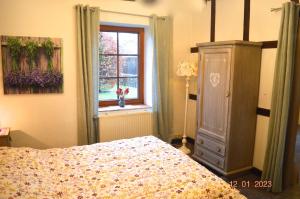 a bedroom with a bed and a dresser and a window at La porte des fagnes in Malmedy